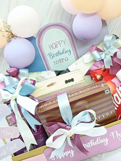 A closer look at the personalized birthday hamper, highlighting the custom 'Happy Birthday Nyrika' details and the beautiful pastel ribbon work.