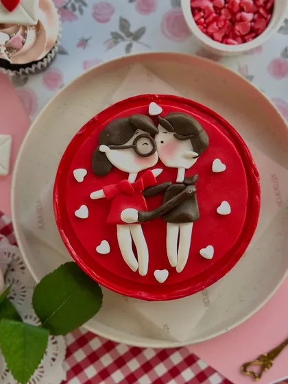 A sweet, cartoon-style bento cake for Valentine's Day, featuring an adorable kissing couple.