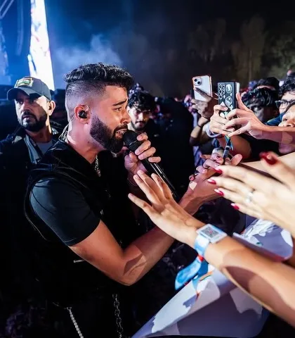 I bridge the gap between the artist and the fans. Here's AP Dhillon getting up close with the crowd, creating an intimate moment amidst a massive concert. It's all about that personal connection and raw energy.