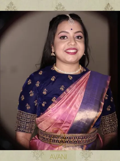 A client in a navy blue velvet blouse with delicate gold embroidery. The rich fabric and boat neckline offer a regal and sophisticated option for evening events.