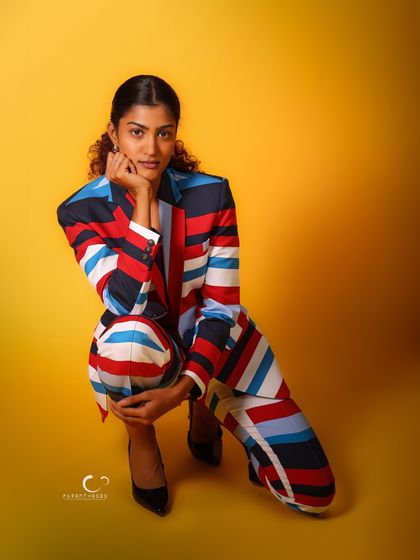 A low-angle, crouching pose that feels modern and edgy. The composition is dynamic and full of energy, perfectly matching the vibrant outfit.