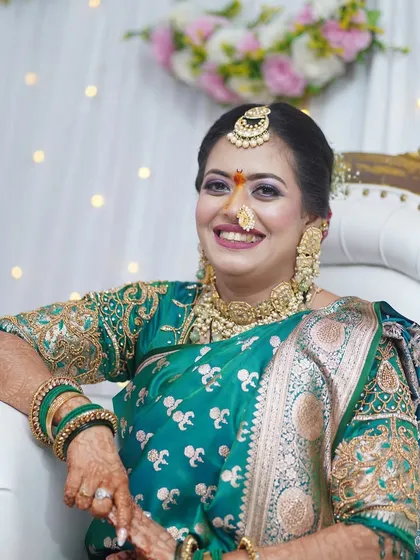 A beautiful engagement look in a traditional green saree. The makeup features a pop of color on the eyes and a warm lip, creating a fresh and celebratory feel.