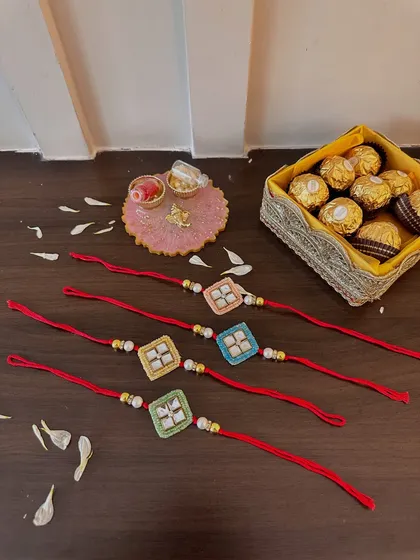 A flat-lay of my colorful square-shaped rakhis, paired with a pink resin thaali and a box of Ferrero Rocher. It’s a simple yet thoughtful combination for your brother.