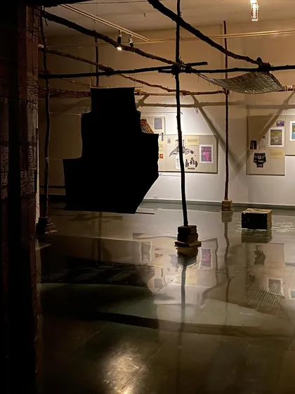 A view of the installation showing the raw, wooden structure that held the textile pieces.