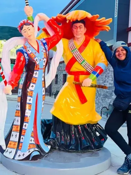 A traveler posing with colorful local statues. The journey is also an opportunity to connect with the vibrant culture of Tibet.