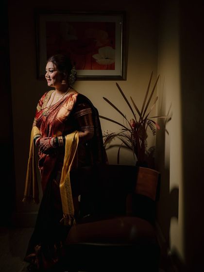 A beautifully lit solo portrait of the bride, Ekta, standing in a quiet corner. The play of light and shadow creates a dramatic and artistic effect.