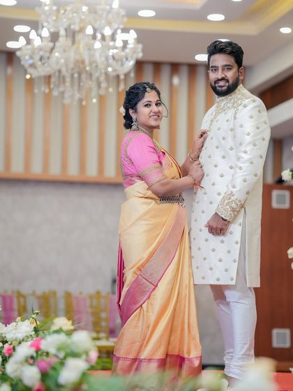 Another shot of the couple, showing how his elegant white sherwani complements her vibrant saree, creating a balanced and beautiful look.