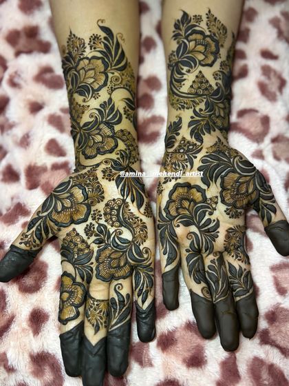 The contrast in this design is created by using bold, dark henna for the flowers and leaves against the lighter, detailed background work.