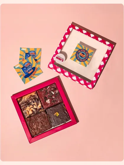 A fun and retro-themed Father's Day gift set featuring brownies and custom-designed cards. The bright colors and flat-lay composition create a playful and eye-catching product shot.