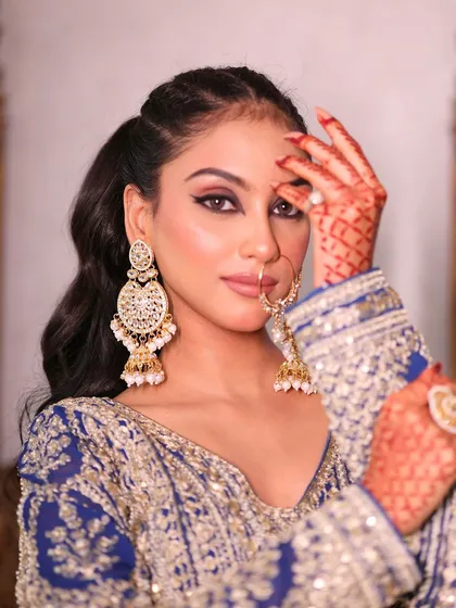 This royal blue and silver lehenga is perfect for a grand reception look. The intricate embroidery and heavy earrings create a truly royal vibe.