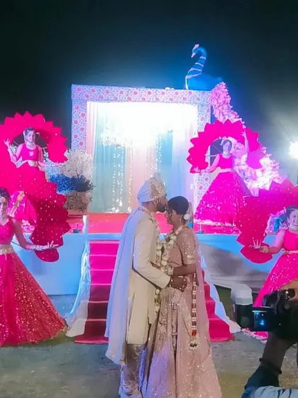 Even the Varmala ceremony can be a grand spectacle. Here, our dancers with elaborate peacock-themed props create a beautiful, symmetrical backdrop for the couple's special exchange.