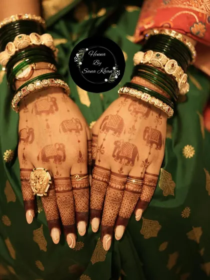 A beautiful design featuring elephant motifs, which are symbols of good luck and prosperity. The rich, dark stain looks stunning against the client's green bangles.