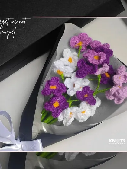 A beautiful "Forget-Me-Not" themed bouquet with purple and white flowers, elegantly packaged in a gift box.