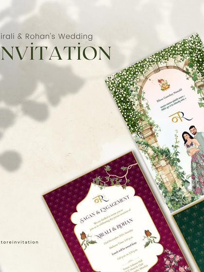 A styled shot focusing on the main wedding and sagan invitations for Nirali and Rohan. The contrast between the lush green floral arch and the rich purple damask pattern showcases a versatile and luxurious design approach.