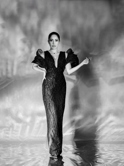 A powerful, centered, full-length portrait that combines classic glamour with a modern, artistic background effect.