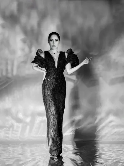 A powerful, centered, full-length portrait that combines classic glamour with a modern, artistic background effect.