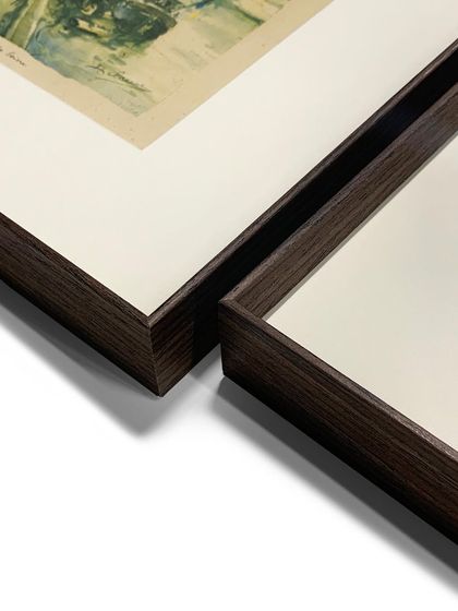 A close-up on the corner of our brown metal frame. The slim profile and wood-grain finish offer a modern yet warm aesthetic that complements a wide variety of art styles.