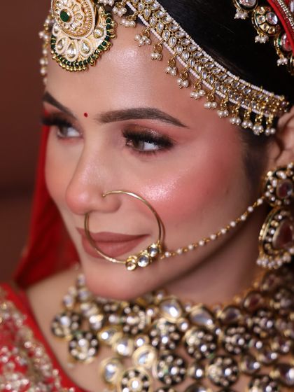A side profile of our gracious Rajwada bride. This angle highlights the contour, the shimmer on the eyelids, and the intricate matha patti hairstyle.