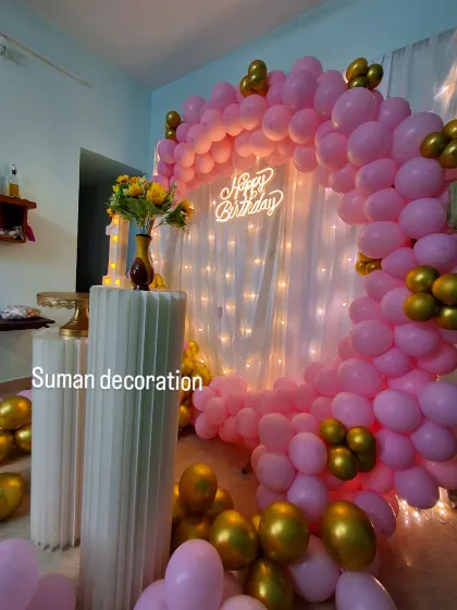 A close-up of the cozy pink and gold birthday corner, highlighting the neon sign and balloon details.