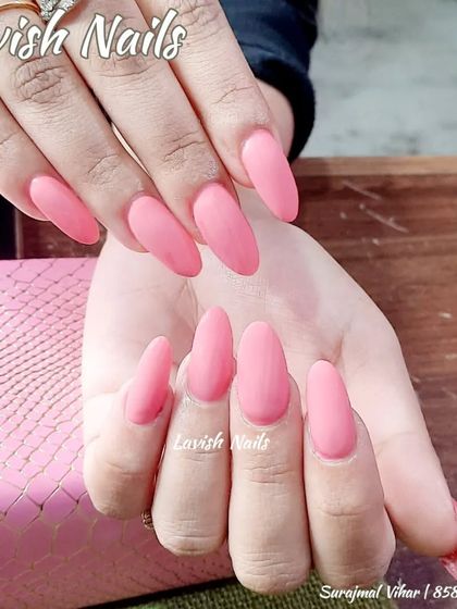 A full set of long, almond-shaped nails in a beautiful matte pink finish.