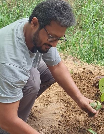 A volunteer from NTT DATA gets his hands dirty, planting a native sapling. Each person's effort contributes to the larger goal of restoring Gurgaon's wild heart.