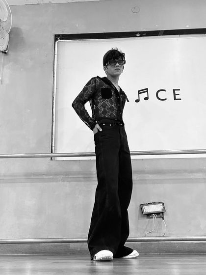 A black and white photo in a dance studio, standing in front of a whiteboard with the word "DANCE". This captures my connection to the art form.