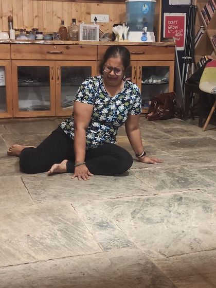 A participant exploring movement and space on the floor during an intense, immersive session in the Himalayas.