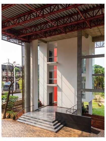 The entrance lobby beneath "Hoverspace" is a bright, open volume defined by the supporting columns and the exposed red-painted roof structure of the terrace above.