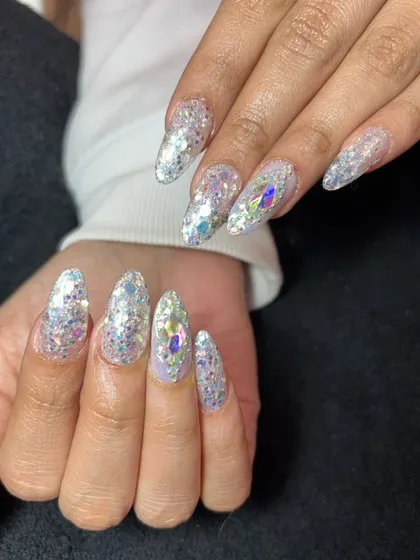 This set is all about the sparkle. Long, almond-shaped nails are fully covered in chunky silver and holographic glitter, with large iridescent crystals for an extra dazzling effect.