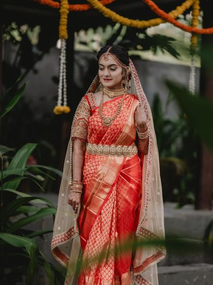 A full-length shot showing the beautiful fall of the saree and the complete bridal styling.