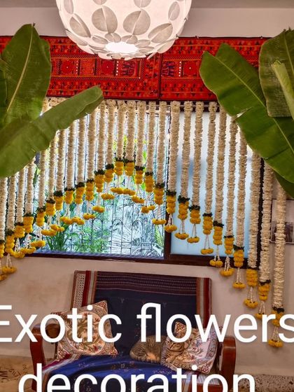 A classic South Indian style decoration. This window is framed with hanging strings of jasmine and marigolds, flanked by banana trees for an authentic and traditional feel.