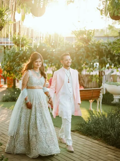 Bathed in the golden hour light, Avi and Devika make their entrance at the Gallops. This wide shot captures the beautiful ambiance of the venue and the couple's graceful presence.