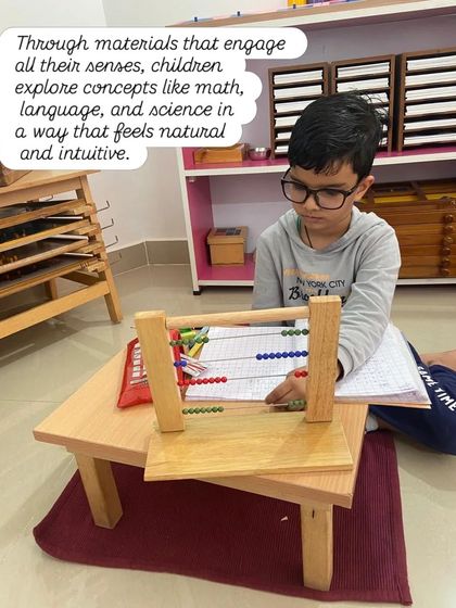Through materials that engage all their senses, children explore concepts like math, language, and science in a way that feels natural and intuitive. This child is using the bead frame to understand complex arithmetic.