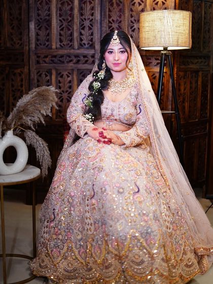 A seated portrait showcasing the immense flare and detailed peacock embroidery of the lehenga.