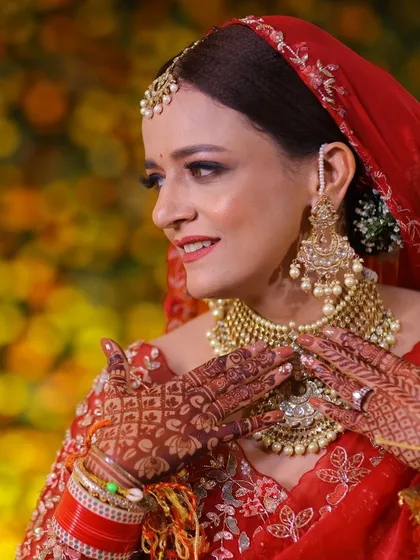 A close-up of this radiant bride in a red saree. The makeup is classic and clean, letting her natural beauty and the richness of her outfit shine.