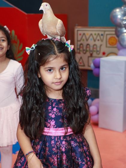A magic show is a fantastic way to entertain guests of all ages. Here, a little girl is amazed as a dove appears as part of a trick during the Frozen party.
