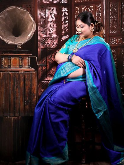 Another pose from this traditional session, with the mom-to-be seated, looking down lovingly at her bump. The composition is classic and full of grace.