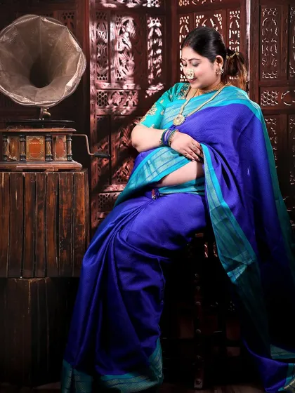 Another pose from this traditional session, with the mom-to-be seated, looking down lovingly at her bump. The composition is classic and full of grace.