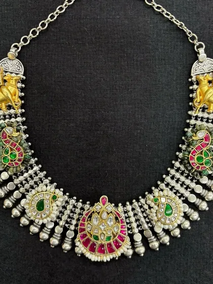 A beautiful fusion necklace set featuring camel and peacock motifs. The design mixes oxidised silver with gold-plated accents and colourful Kundan work, creating a piece that's rich in detail and tradition.