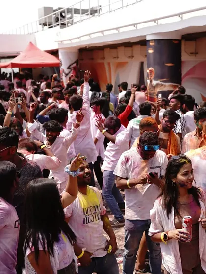 A snapshot of the vibrant and energetic crowd at the Holi 2024 party, with people dancing and capturing memories.