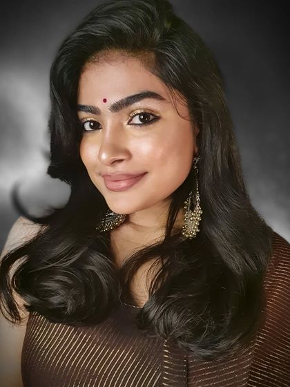 A festive look perfect for a sangeet or wedding guest. The focus is on warm, shimmery golden eyeshadow and defined eyes, paired with traditional chandbali earrings.