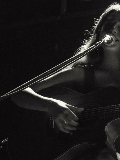 A black and white close-up of me singing during a duo performance. The focus is purely on the music and emotion.