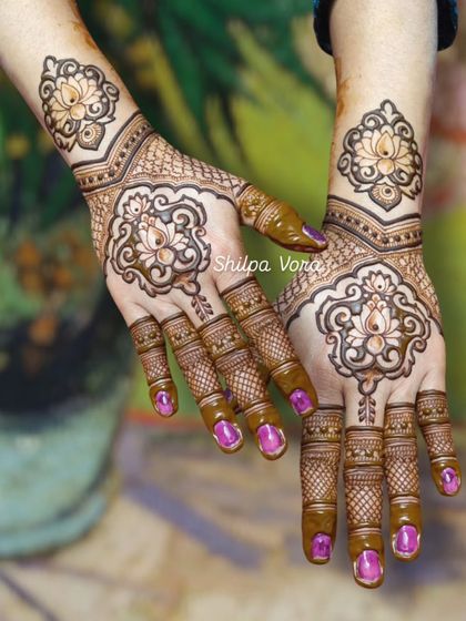 A stunning lotus design with intricate shading and detail work on the fingers, shown on both hands.