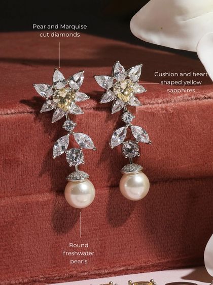 A detailed view of the earrings from the Yellow Sapphire set. They feature cushion and heart-shaped yellow sapphires, pear and marquise-cut diamonds, and round freshwater pearls.