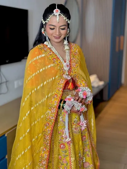 A full view of this stunning Haldi bride. The floral kalire and jewellery set were designed to match her vibrant yellow lehenga, creating a cohesive and absolutely beautiful look.