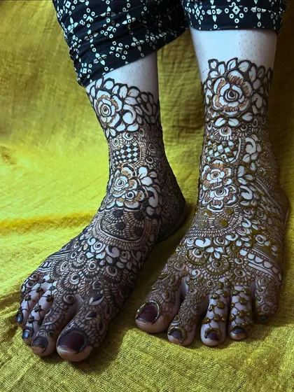 This photo captures the full view of the intricate bridal foot mehendi, showing how the design covers the toes, foot, and ankle.