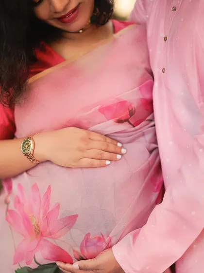 A close-up detail shot focusing on their hands cradling the baby bump. This image symbolizes their shared journey of love and the new life they have created together.