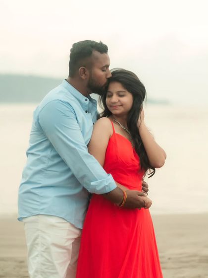 A tender kiss on the forehead. This intimate moment is beautifully captured during a beach pre-wedding shoot, featuring our simple red gown.