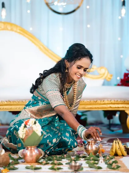 Bride Siddhi performing her engagement rituals. Her makeup is set to last through all the ceremonies, keeping her looking fresh and radiant in her beautiful teal saree.