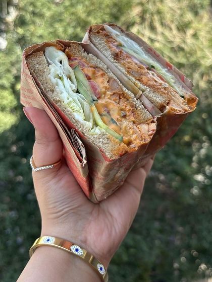 Those buns, though! A tempting close-up of our chicken sandwich, showcasing the hearty bread and generous fillings that make it a favorite among our customers.